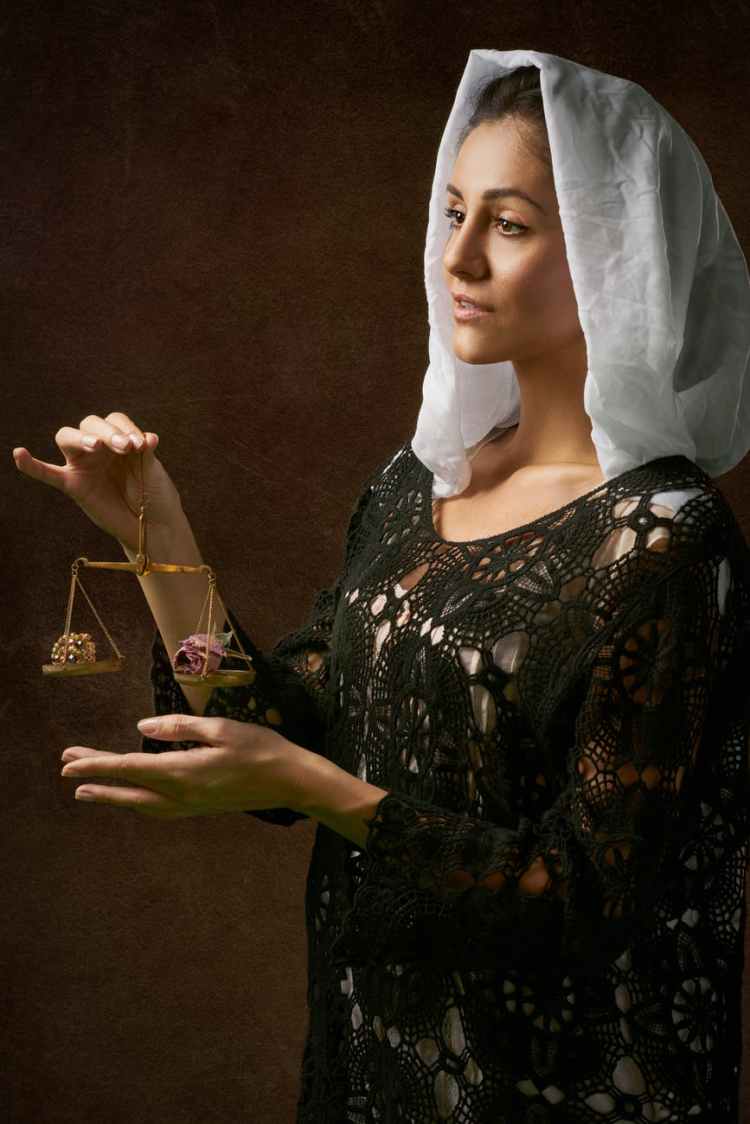 woman in black dress holding balance scale